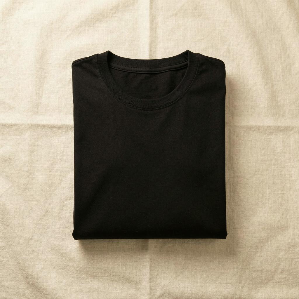 A neat stack of folded black crew-neck tees